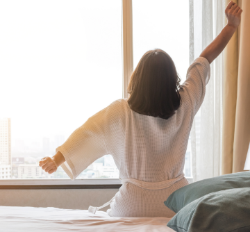 A woman stretching after a good night's sleep
